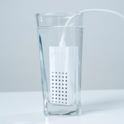 EcoloxTech Micro portable hypochlorous acid generator in a glass of water