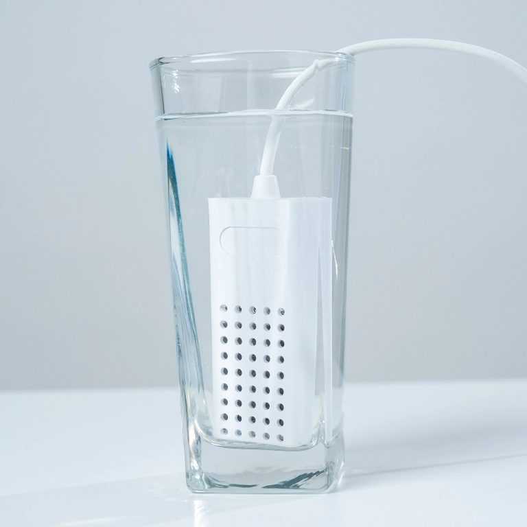 EcoloxTech Micro portable hypochlorous acid generator in a glass of water